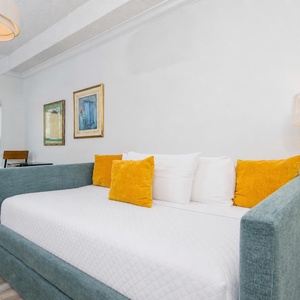 Bright and inviting room featuring a cozy twin daybed with a twin trundle, yellow accent pillows and a scenic view