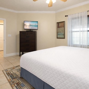 Relax in your king guest suite, enjoying soft bedding and a cozy vibe while catching a show on the TV