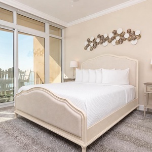 Retreat to the king master suite with cozy bedding and drift off to the sound of the waves from the balcony