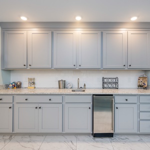 Grab a chilled drink from the fridge or create your favorite cocktail at the wet bar with sleek cabinetry and fun decor