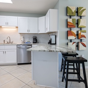Prepare meals and enjoy drinks at the stylish breakfast bar, surrounded by vibrant leaf artwork and a welcoming vibe