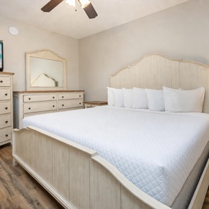 Unwind in this serene bedroom featuring a comfortable king bed, stylish furniture, and a TV for your entertainment