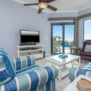 Relax in the inviting living area with cozy seating, a queen sofa sleeper, large TV, and beachfront balcony access