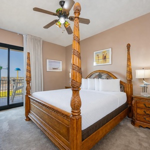 Enjoy restful nights in this master bedroom featuring a four-poster king bed and easy access to the outdoor patio