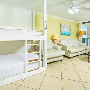 White leather seating and twin bunks create a cheerful space to relax and watch your favorite show