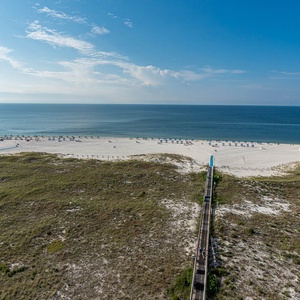 Stunning view of the beach with colorful umbrellas, leading to the calm gulf waters under a clear blue sky