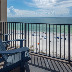 Relax in comfortable chairs while enjoying the expansive view of the beach and water from your balcony