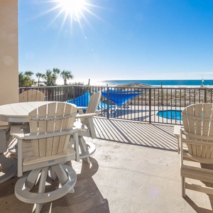 Relax on the spacious beachfront balcony, enjoying views of the pool and the shimmering beach beyond