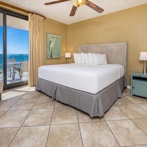 Relax in the master bedroom featuring a comfortable king bed, soft lighting, and beachfront balcony access