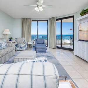 Spacious living area with a sofa with queen sleeper, large TV, and beautiful beach views