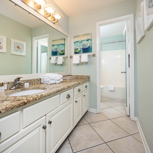 Spacious master bathroom featuring a granite countertop, stylish decor, and ample storage for your essentials