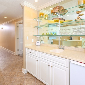 Experience the inviting wet bar, perfect for crafting refreshing drinks as you unwind after a day of fun at the coast