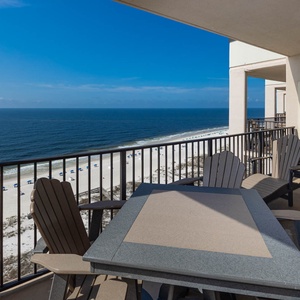 Relax on the balcony enjoying panoramic views of the tranquil waters and beach umbrellas below