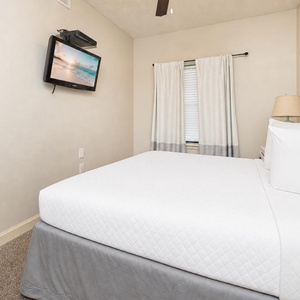 In the guest suite with queen bed, you settle in to watch a favorite show on the wall TV after a busy day