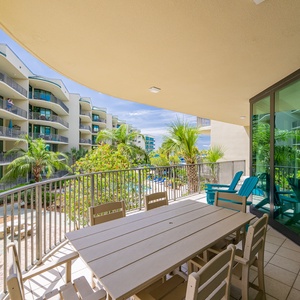 Relax on the spacious balcony, soaking in the tranquil ambiance with lush greenery and poolside views