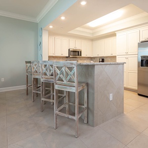 Savor your morning coffee at the breakfast bar and get ready for a beach day in this stylish space