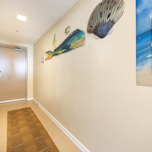 Step into a welcoming hallway adorned with coastal decor, leading you to your beachfront getaway