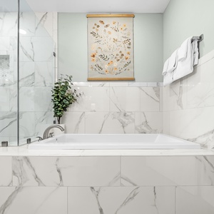 Slide into the tub and let veined tile and ambient lighting soothe you in this elegant master bath