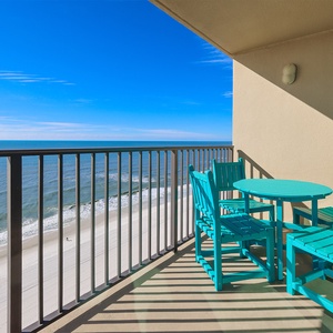 Relax on the balcony with turquoise seating, enjoying refreshing breezes and expansive beach views