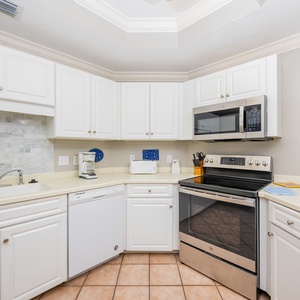 Prepare meals in this kitchen with sleek cabinetry, stainless appliances, and stylish backsplash