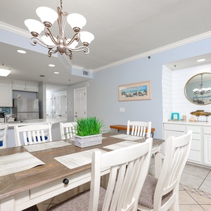 This dining area features a rustic table, white chairs, and a stylish wet bar, perfect for entertaining with a beach view