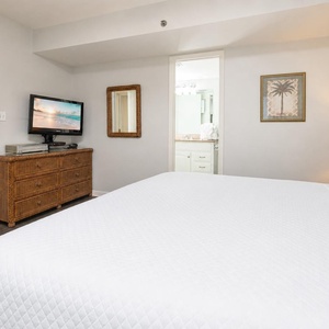 Crisp linens cover your king bed where you rest after a day of family fun by the shore