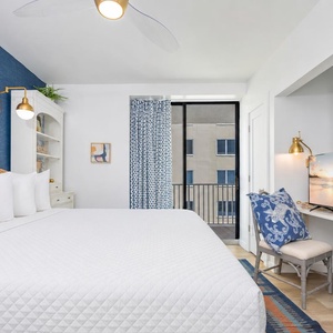 Chic guest bedroom featuring a cozy king bed, vibrant decor, and a TV for entertainment