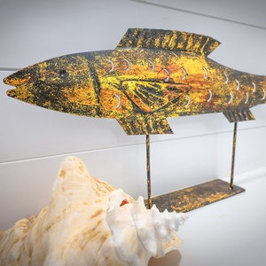 This decor features a vibrant fish sculpture and a large seashell, adding a coastal charm to the space