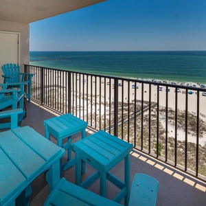 Enjoy the balcony in vibrant blue seating, relaxing with views of the shoreline and tranquil waters below