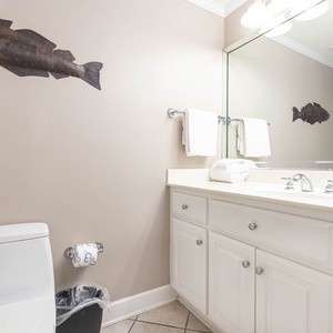 Guest bathroom featuring a spacious vanity with ample counter space, decorative fish art, and fresh towels for guests