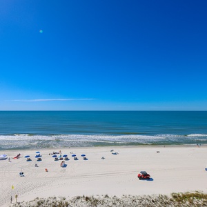 This stunning beachfront view showcases soft sands and vibrant umbrellas, perfect for a relaxing day by the water