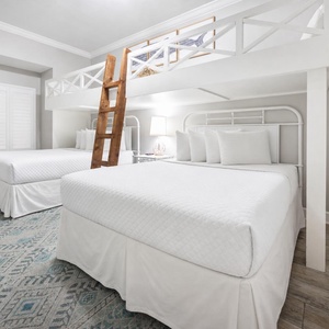 Charming bunk room with two lofted twin beds above two cozy queen beds below