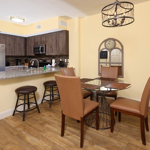 This modern kitchen features stainless appliances, granite countertops, and a cozy dining area with stylish seating