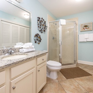 Additional bathroom featuring a walk-in shower, laundry area with washer/dryer, elegant countertops, and fresh towels