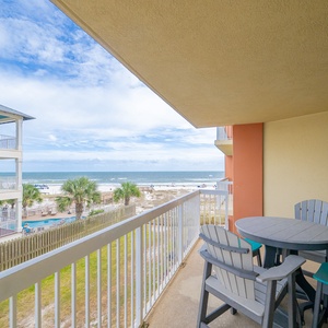 Relax on the private balcony with comfortable seating and enjoy the beautiful coastal view just steps from the beach