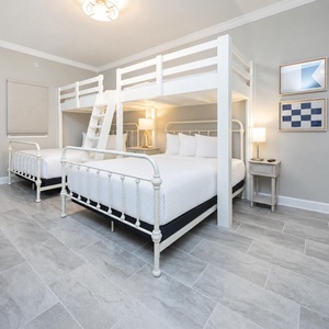 Cheerful guest bedroom featuring twin loft bunks, two queens below, and stylish decor for a fun family getaway