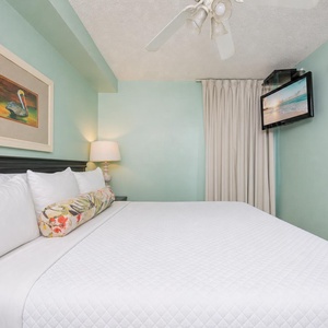 Fluffy pillows invite you to relax in the king suite for a calm movie night after a fun day at the beach