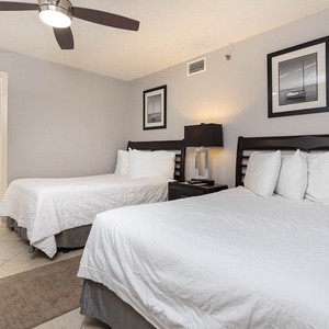 This guest bedroom features two comfortable double beds, modern decor, and an en-suite bathroom for added convenience