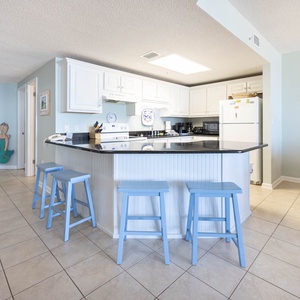 Gather around the spacious breakfast bar with seating, perfect for coffee and conversations during your stay