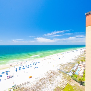 Breathtaking view of the beach with soft white sand and gentle waves under a bright blue sky, perfect for relaxation