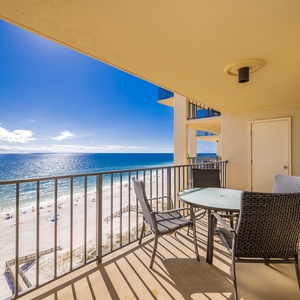 Enjoy breathtaking views from the balcony, featuring a table and chairs perfect for relaxing by the beach