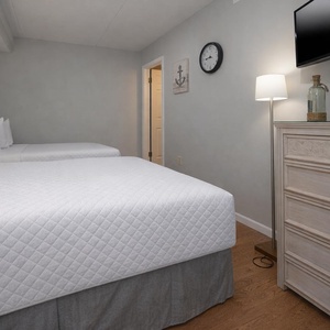 Inviting guest suite with two cozy double beds, stylish decor, and a cozy ambiance for a restful stay