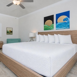 Experience comfort in this inviting guest bedroom featuring a king bed, two sleeping charis, and stylish decor