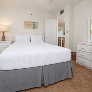 Guest bedroom featuring a plush queen bed, soft lighting, and coastal decor for a relaxing getaway