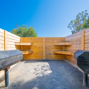 Gather with friends in this private grilling area, perfect for outdoor meals and relaxation under a bright blue sky