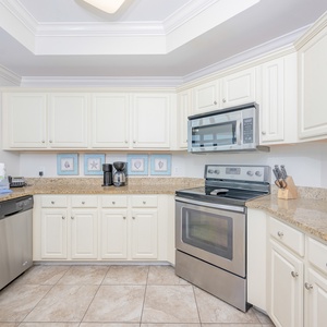 Kitchen featuring stainless appliances, granite countertops, coffee station, and coastal decor for a refreshing atmosphere