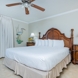 The cozy master bedroom features a king bed, elegant furnishings, and beachfront balcony access