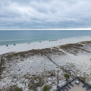 Relax with a view of the pristine beach and calm waters, perfect for a relaxing getaway with lounge chairs and umbrellas