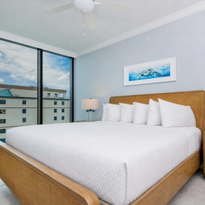 Relax in this serene guest bedroom featuring a king bed, stylish decor, and large windows with scenic views