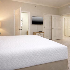 Cozy guest bedroom featuring a king bed, a flat-screen TV, and warm lighting for a relaxing atmosphere